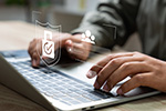 Mann tippt auf Laptop
